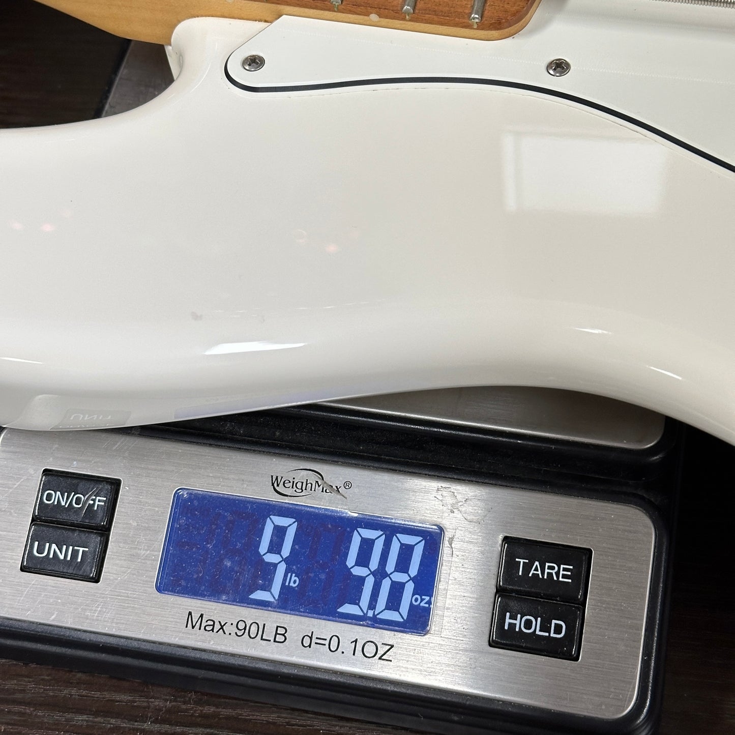 White electric guitar on a digital scale displaying weight