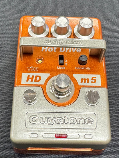Guyatone guitar effects pedal with orange and silver design on a gray background