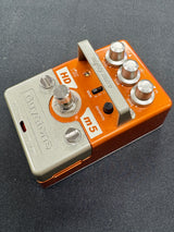 Orange and silver guitar effects pedal on a dark background