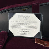 A framed Certificate of Authenticity from Custom Shop for a Martin guitar, displayed inside a dark velvet-lined case with a leather pickguard visible at the bottom right.