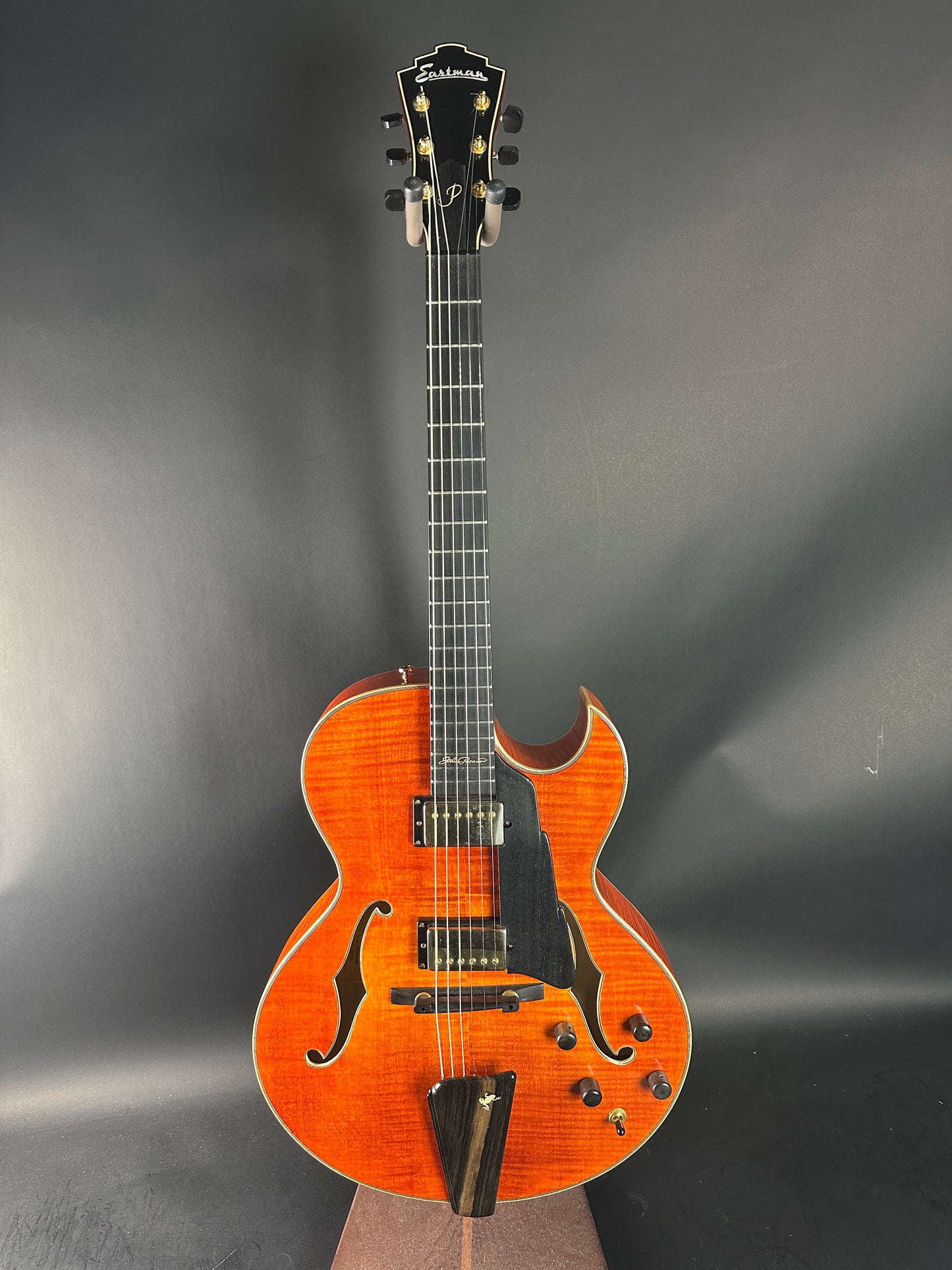 Orange acoustic guitar on a gray background