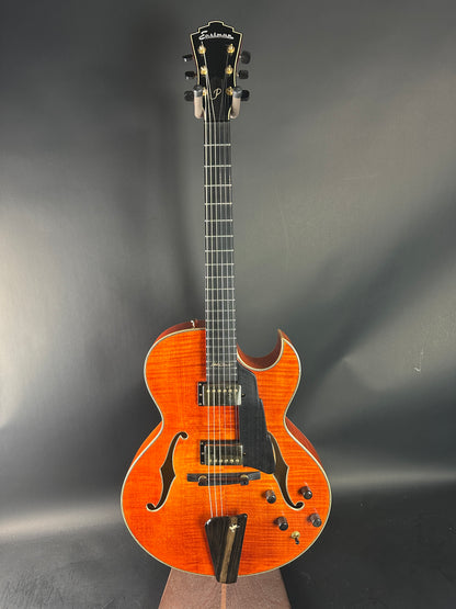 Orange acoustic guitar on a gray background