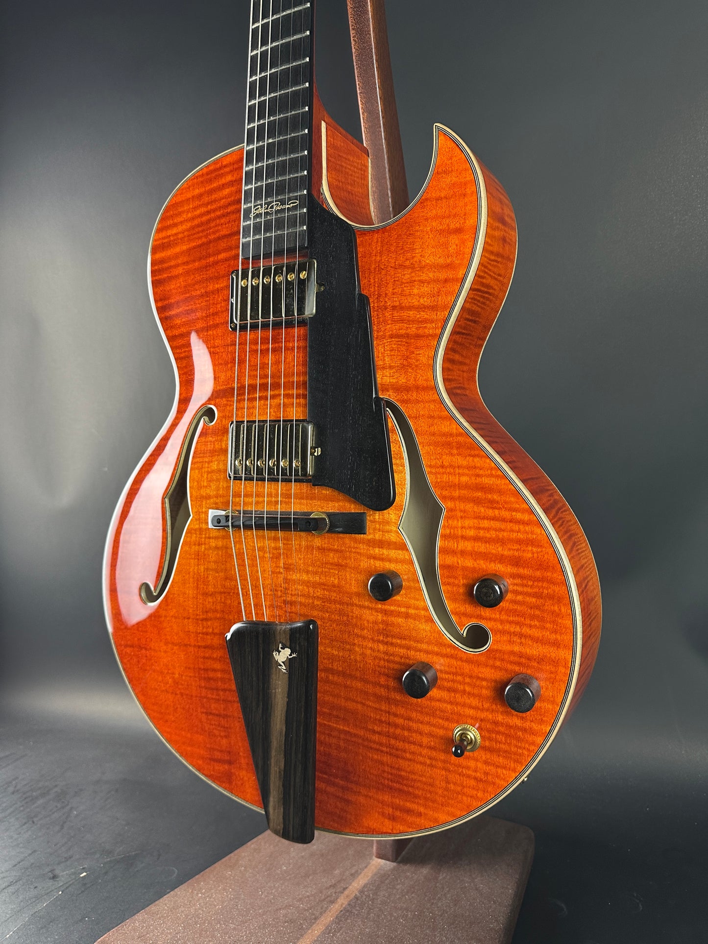 Close-up of a wooden electric guitar on a dark background