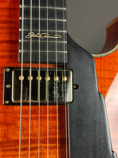 Close-up of a guitar with a visible brand logo on the neck