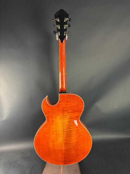 Wooden acoustic guitar on a reflective gray surface
