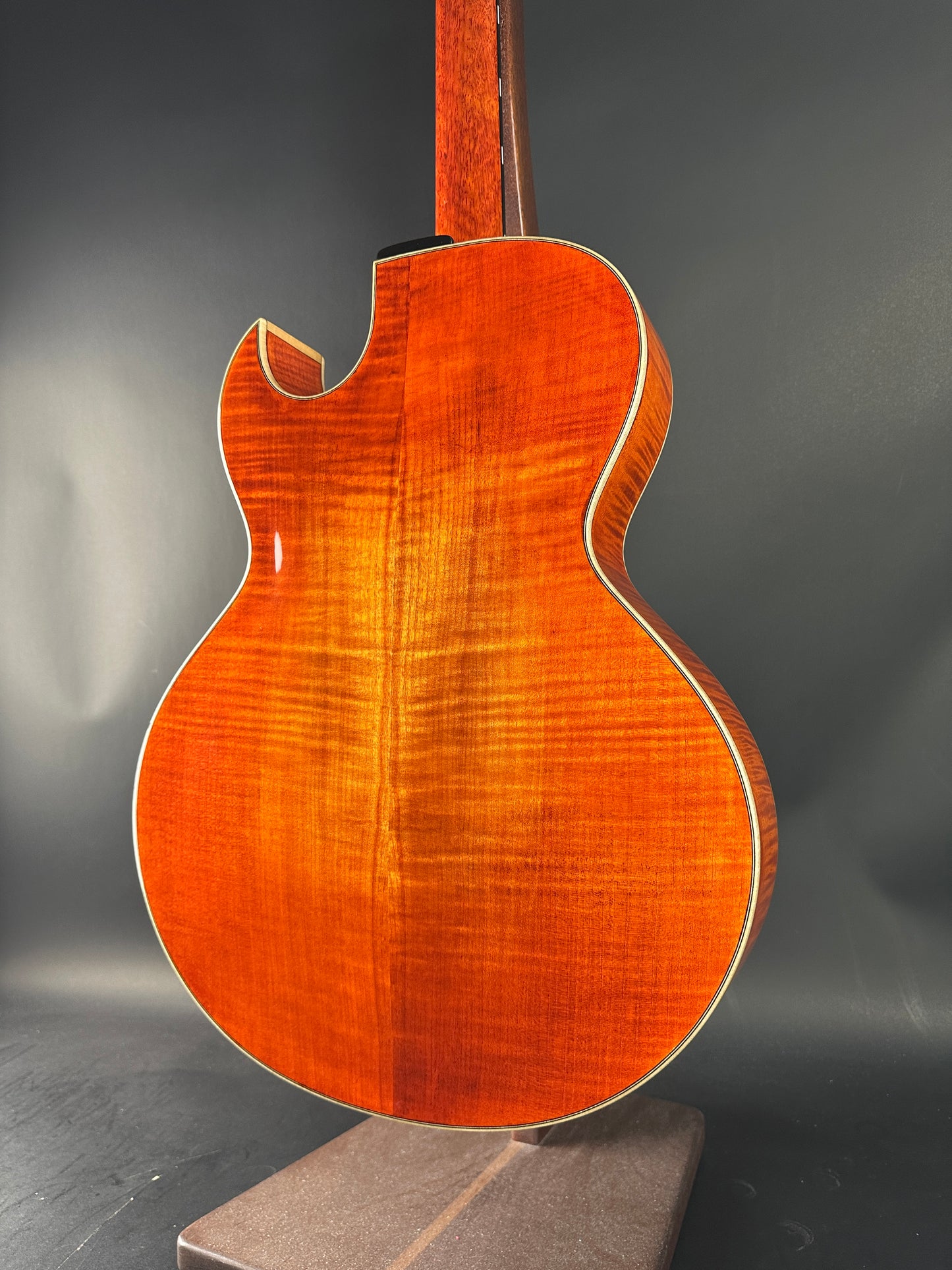 Close-up of a wooden acoustic guitar on a dark background