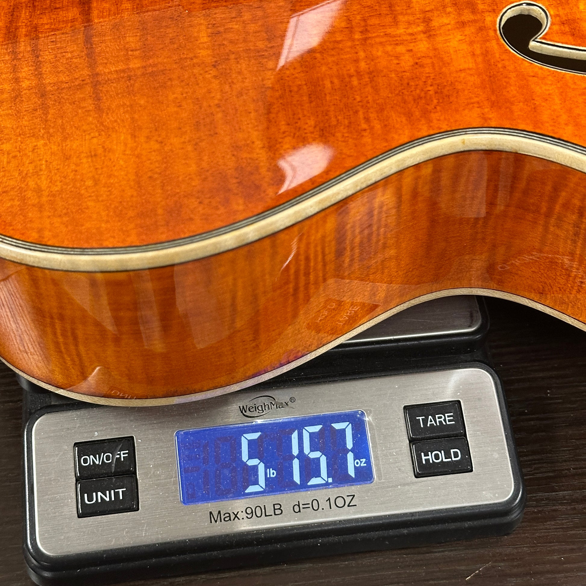 Guitar on a digital scale displaying weight