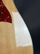 Close-up of a guitar's soundhole and body with a dark background