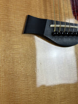 Close-up of a guitar's soundhole with a white square on a textured brown surface