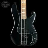 A black electric bass guitar with a maple neck and white pickguard, shown against a solid black background. A Tone Shop watermark is visible in the top-left corner.