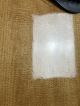 Square patch of white fabric on a brown textured surface