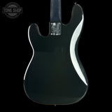The back of a black electric guitar with a glossy finish, featuring a chrome 'Tone Shop' emblem on the back plate, set against a solid black background.
