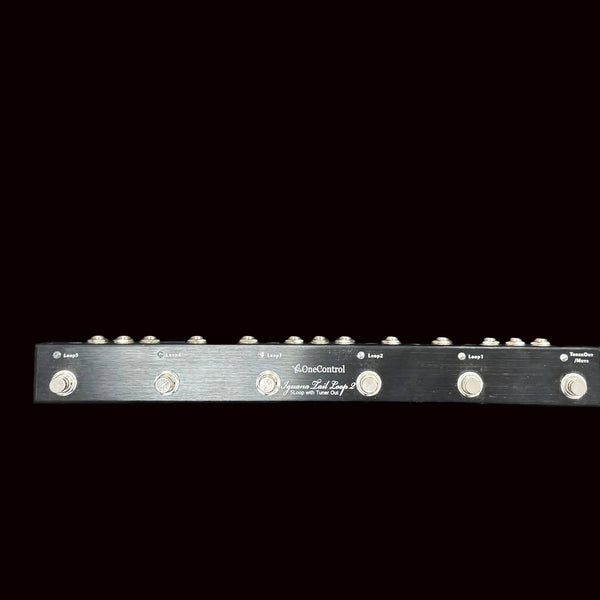 Black guitar effects pedal with multiple knobs on a black background
