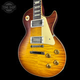 A classic electric guitar with a natural sunburst finish, cream pickguard, and gold hardware, shown against a solid black background with a Tone Shop watermark in the top left corner.