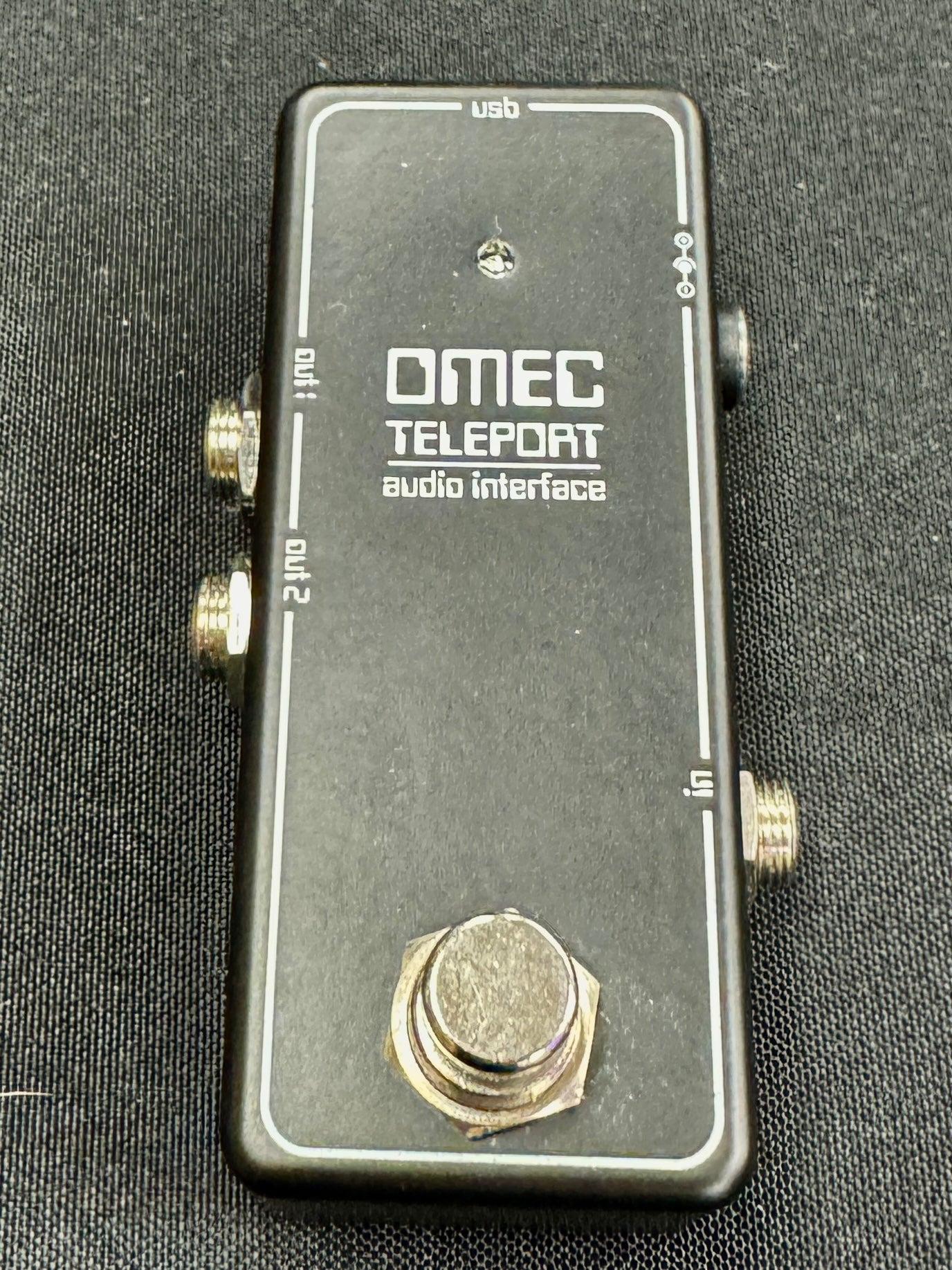 OMEC Teleport audio interface on a dark textured background