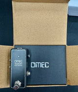 OMEC guitar effects pedal on a cardboard surface