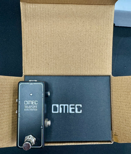 OMEC guitar effects pedal on a cardboard surface