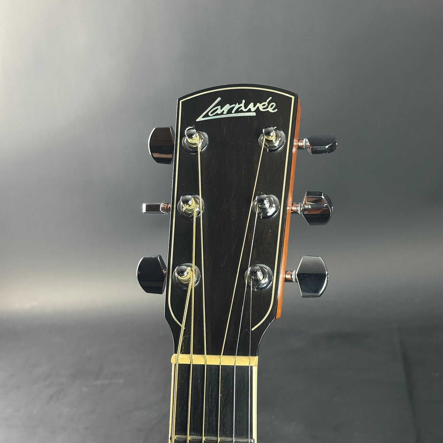 Guitar headstock with 'Larrivee' branding on a gray background