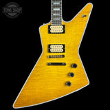 A yellow-flecked flamed maple electric guitar with black hardware and cream pickups, shown against a solid black background. A 'Tone Shop' watermark is visible in the top-left corner.