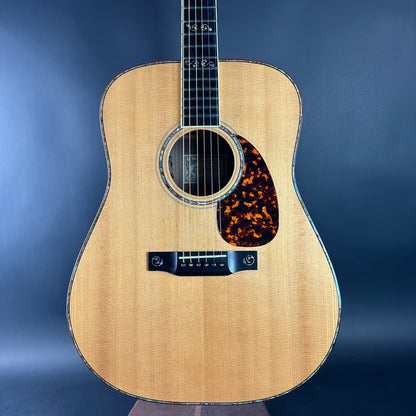 Acoustic guitar with tortoiseshell pickguard on a blue background