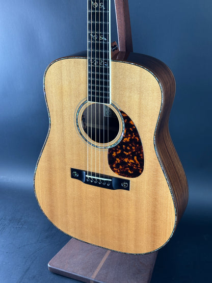 Acoustic guitar with a tortoiseshell pickguard on a blue background