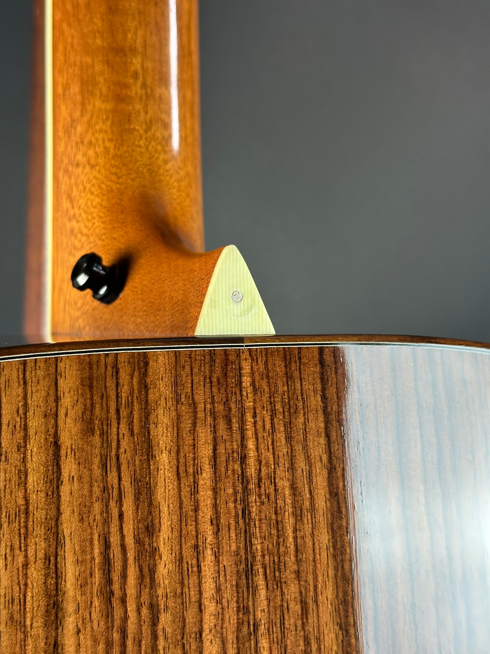 Close-up of a wooden guitar with a focus on the neck and body.