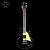 A black electric guitar with cream-colored pickups and trim, shown from the front against a solid black background. The brand name 'Gibson' is visible on the headstock.