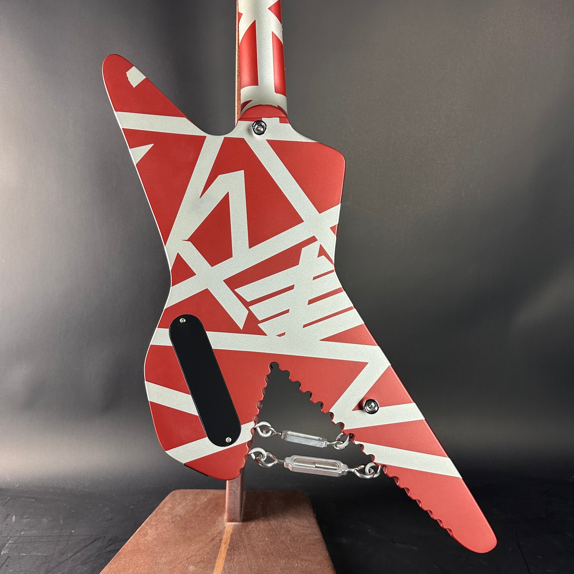 Red and white guitar with geometric pattern on a gray background