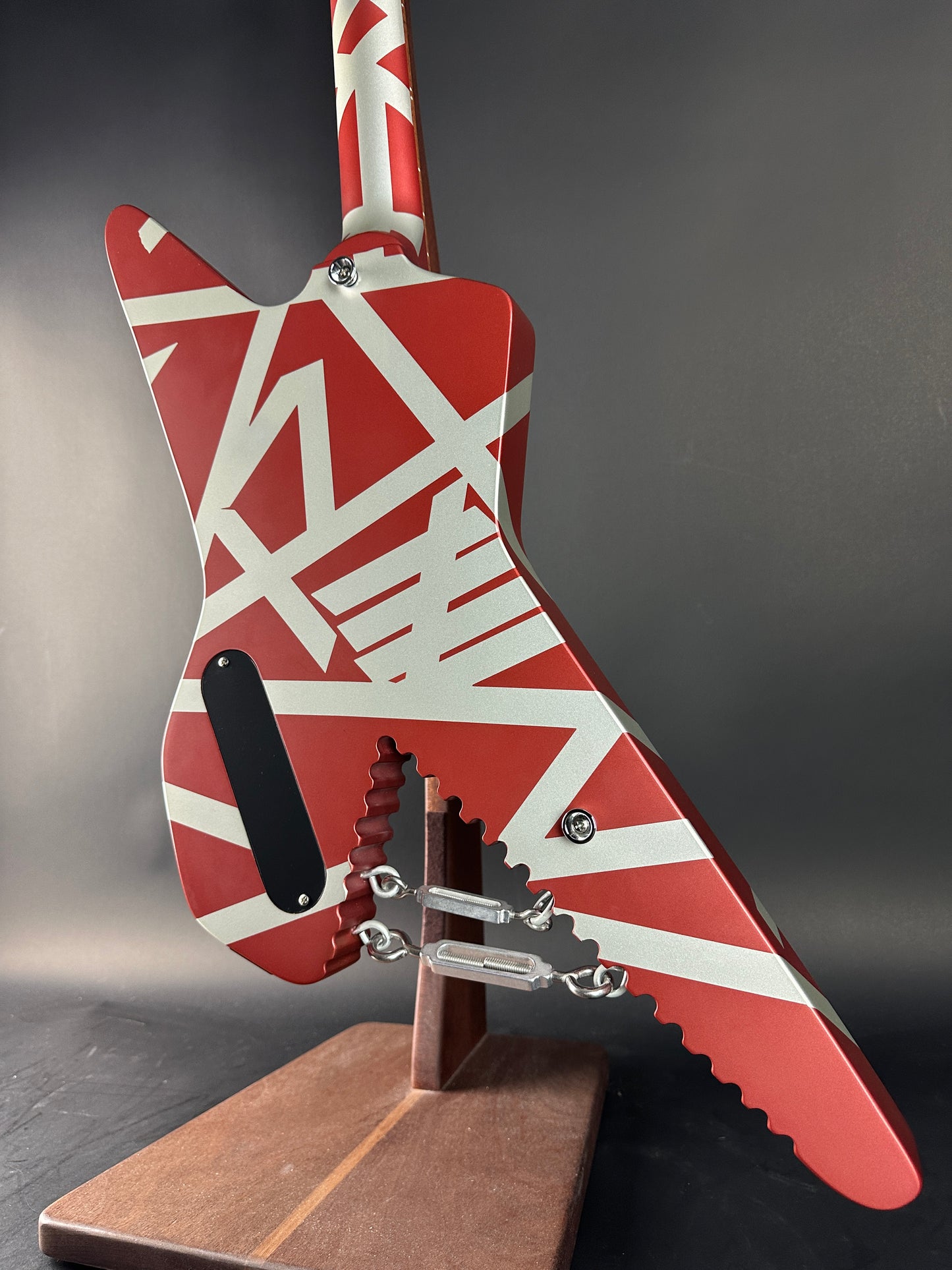 Close-up of a red and white guitar with a unique design on a dark background
