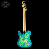 A Fender Telecaster-style electric guitar shown from the back, featuring a vibrant turquoise blue body with a green, yellow, and white floral pattern, set against a solid black background.