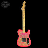 A Fender Telecaster-style electric guitar with a bright pink body featuring gold paisley inlay, a natural wood neck, and black hardware, shown against a solid black background with a Tone Shop watermark in the top left.