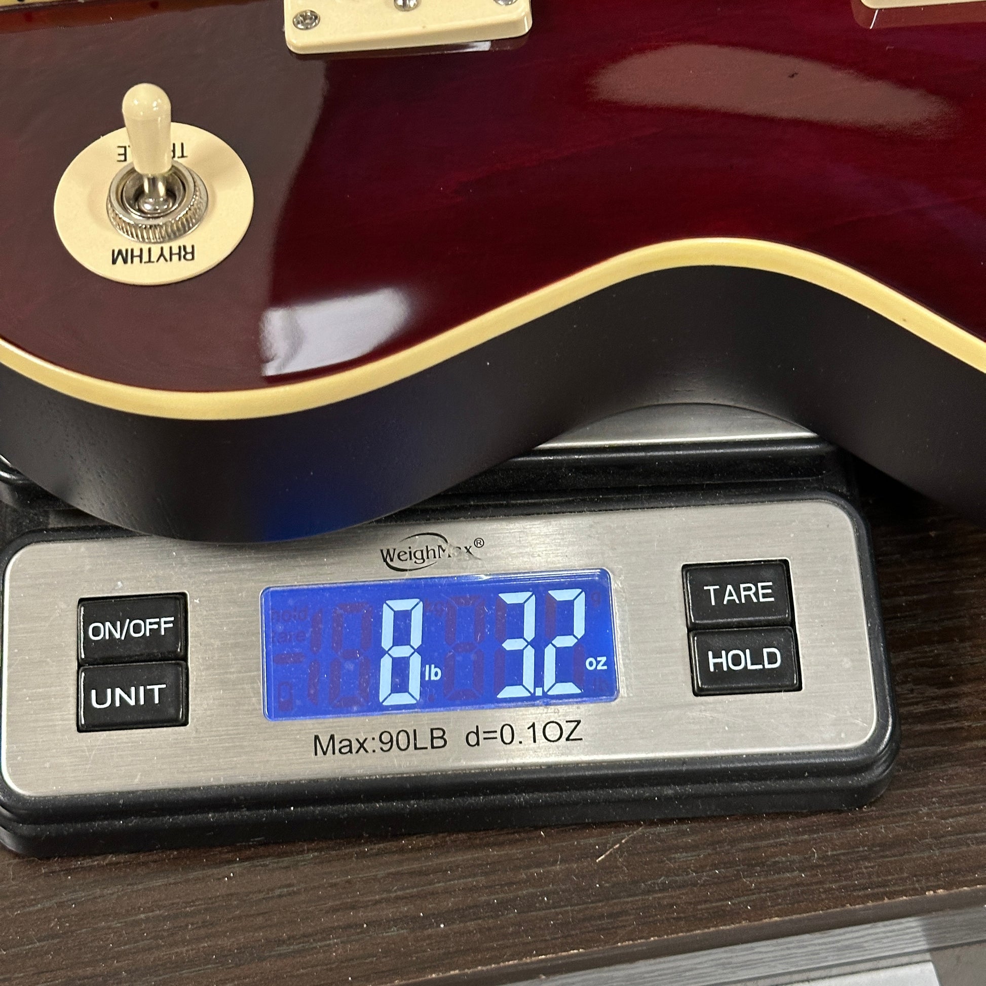 Guitar on a digital scale displaying weight