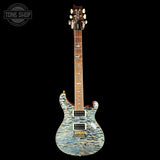 A PRS electric guitar with a blue and white flamed maple top, shown against a solid black background. The brand logo 'PRS' is visible on the headstock, and a 'TONE SHOP' watermark is in the top-left corner.