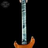 Close-up of the neck and lower body of an electric guitar against a black background, showing a glossy blue and white striped maple neck and a warm brown wood body. A Tone Shop watermark is visible in the top left corner.