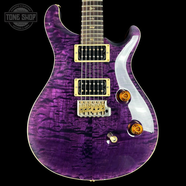 Purple electric guitar with gold hardware on a black background, featuring 'Tone Shop' logo.