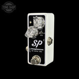 A white and black Xotic SP Compressor guitar pedal against a solid black background, featuring clear plastic knobs and a silver footswitch.