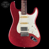 A red glitter electric guitar with a white pickguard and gold hardware, shown against a solid black background. A Tone Shop watermark is visible in the top left corner.
