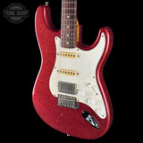A red glitter electric guitar with a white pickguard, shown against a solid black background. A Tone Shop watermark is visible in the top-left corner.