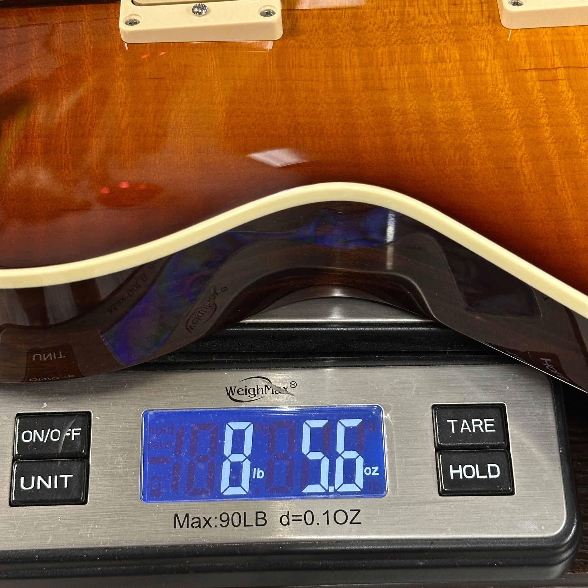 Guitar on a digital scale displaying weight