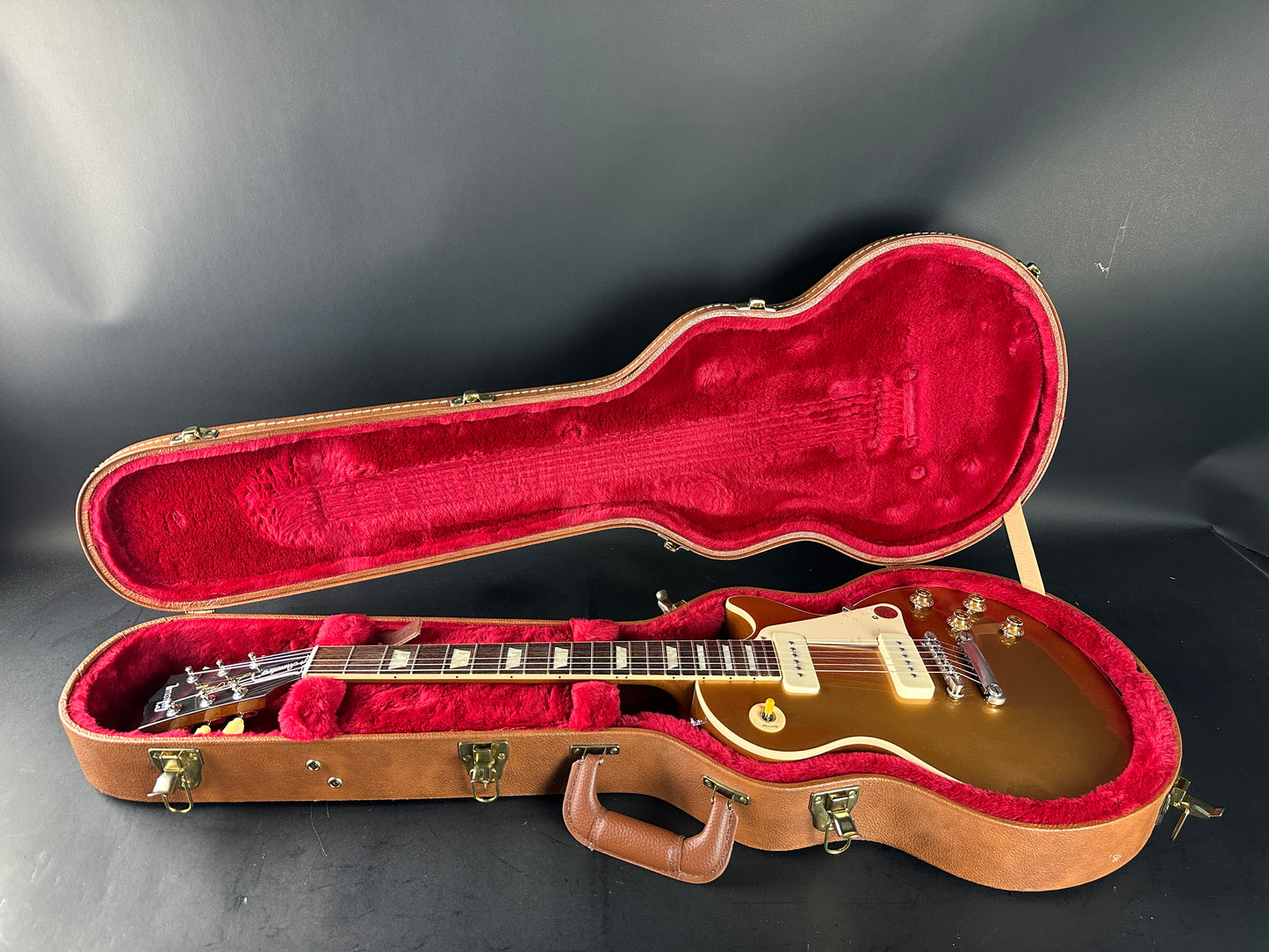 Gibson Les Paul guitar in a red-lined case on a dark background