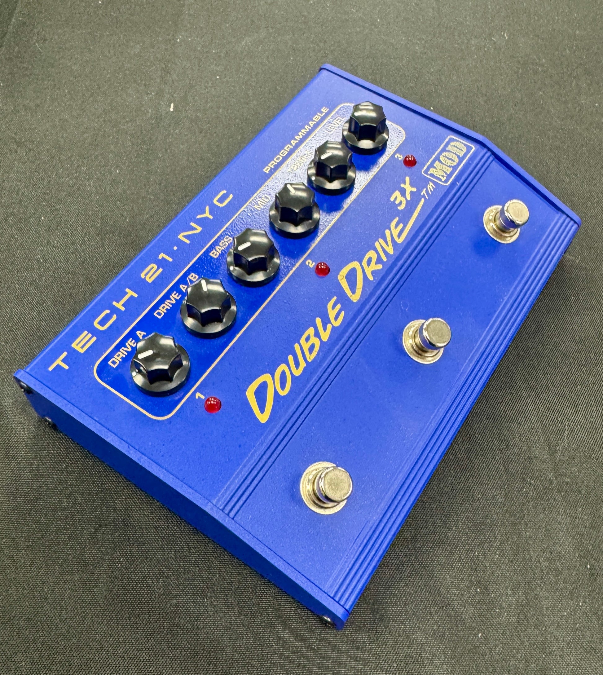 Blue guitar effects pedal with 'Double Drive 3x' on a gray background