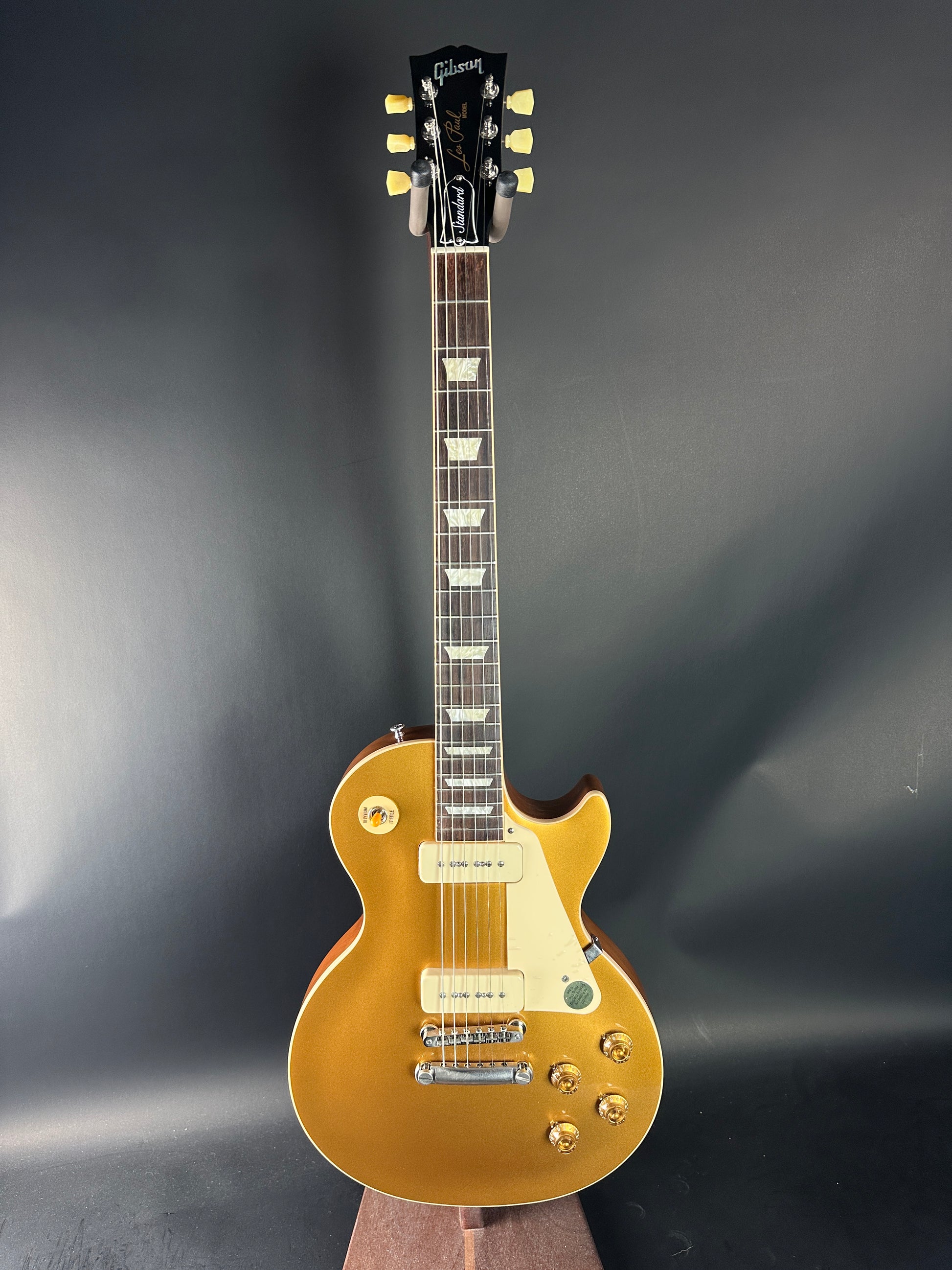 Gold electric guitar on a dark gray background