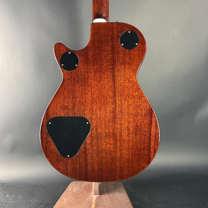 Back view of a wooden electric guitar on a gray background