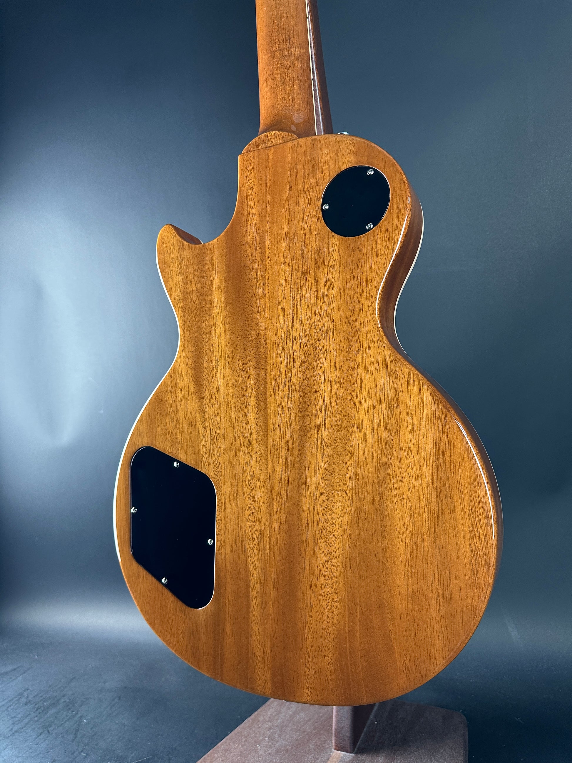Wooden guitar body on a reflective blue surface