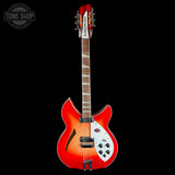 A double-cutaway electric guitar with a vibrant red-to-orange sunburst finish, featuring a white pickguard and black hardware, shown against a solid black background.