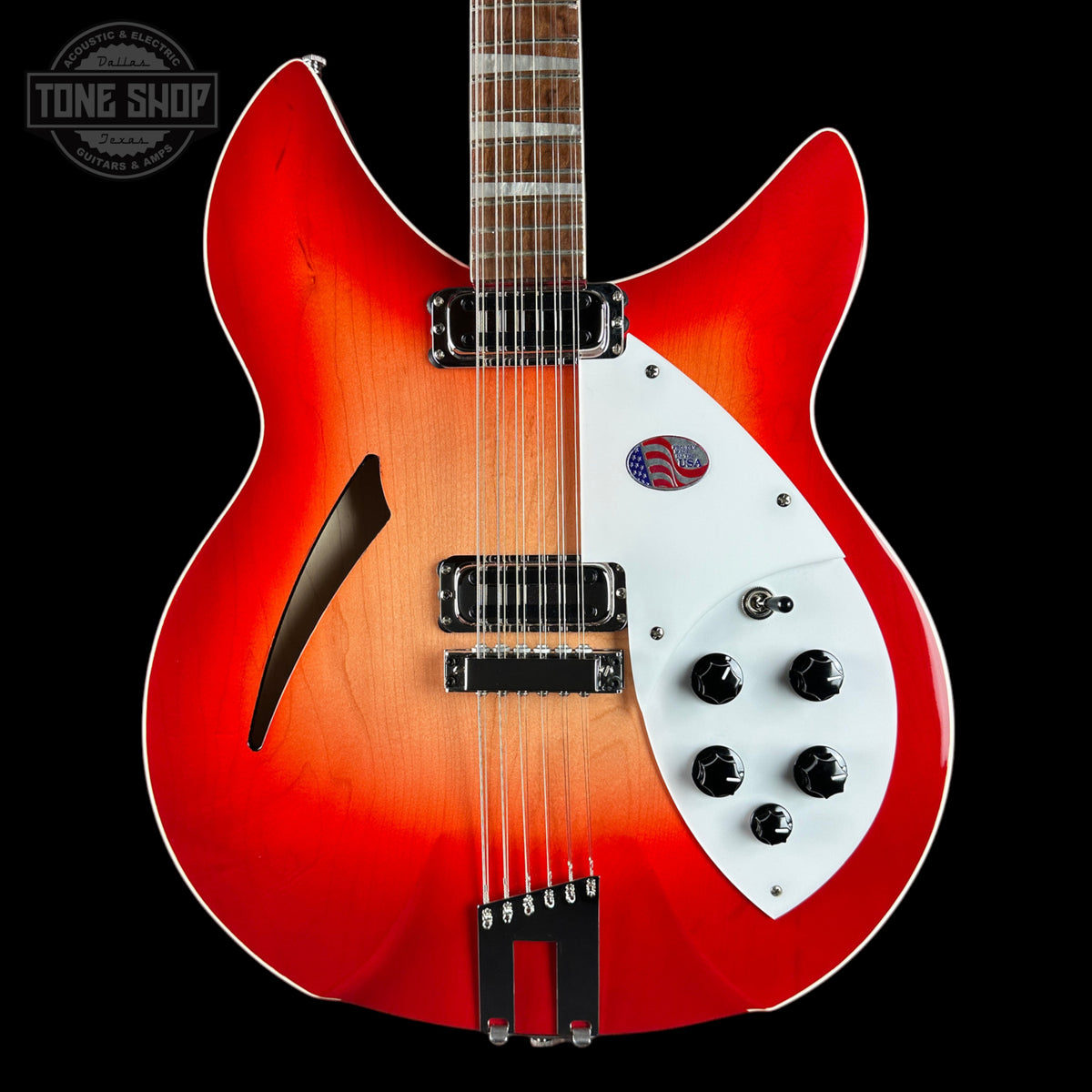 A double-cutaway electric guitar with a vibrant red-to-orange sunburst finish, a white pickguard, and black hardware, shown against a solid black background with a Tone Shop watermark in the top-left corner.