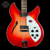 A double-cutaway electric guitar with a vibrant red-to-orange sunburst finish, a white pickguard, and black hardware, shown against a solid black background with a Tone Shop watermark in the top-left corner.