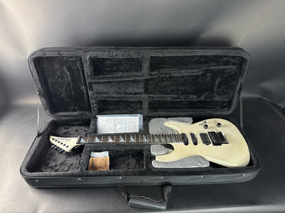 White electric guitar in a black case on a gray background