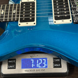 Blue electric guitar on a digital scale displaying weight