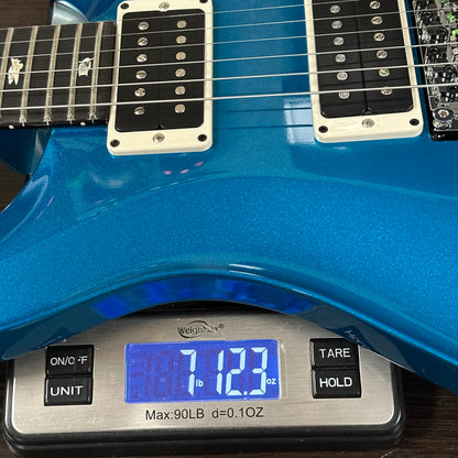 Blue electric guitar on a digital scale displaying weight